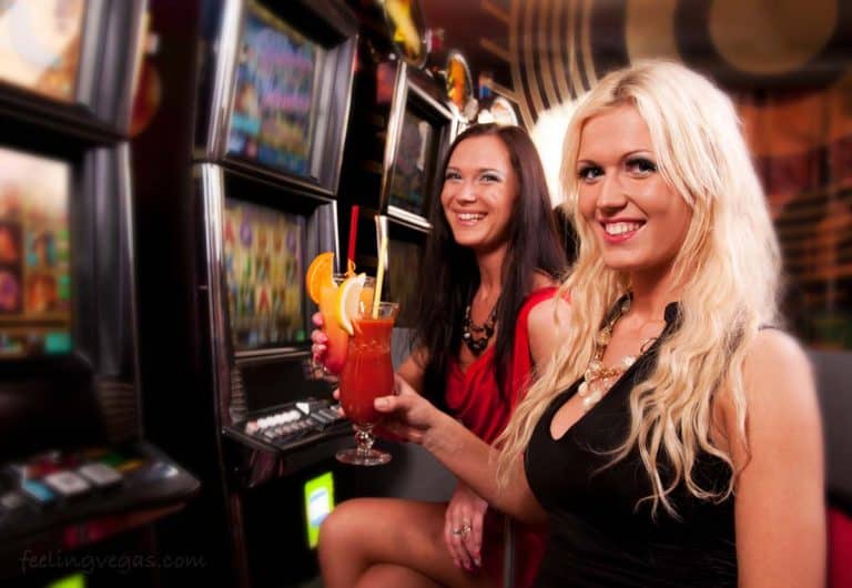 Two women sitting a slot machines with free drinks in Las Vegas.