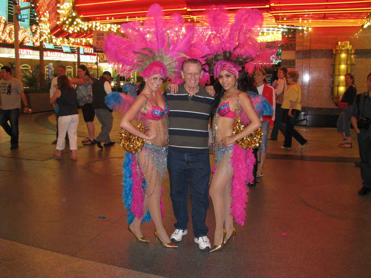 How Much to Tip Vegas Street Performers? (Vegas Tipping) 6 Las Vegas showgirls take a picture with a tourist on Fremont St.